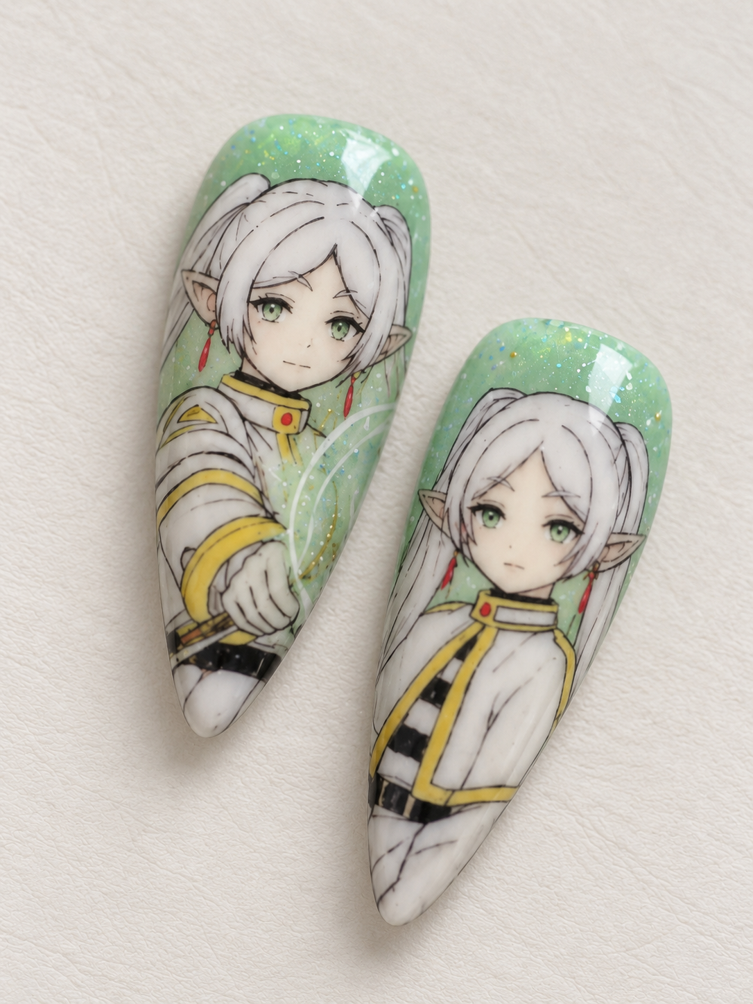 Close-up of Frieren character nail art with sparkling green background
